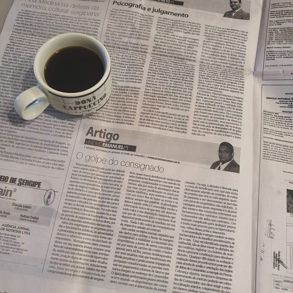 Foto da página física do jornal que circulou no dia 15/12/2021, com um close no artigo publicado e uma xícara de café ao lado